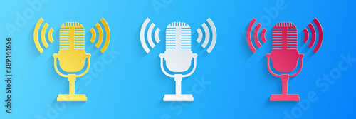 Paper cut Microphone icon isolated on blue background. On air radio mic microphone. Speaker sign. Paper art style. Vector.