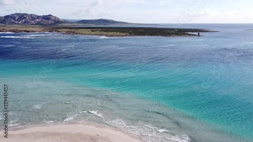 incredibly clear and turquoise water on the white beach of La Pelosa in Stintino (Sardinia), with small waves photo