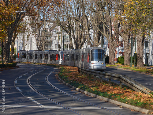 City tram driving on a winding street in the German city of Dusseldorf. Autumn sunny day in the city