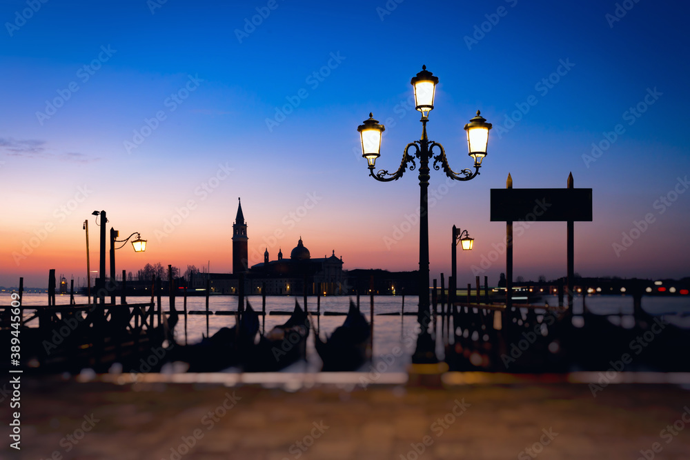 Morning view of the embankment in Venice, Italy. Gondolas parked off the coast. Colorful landscape, long exposure, tilt-shift effect.