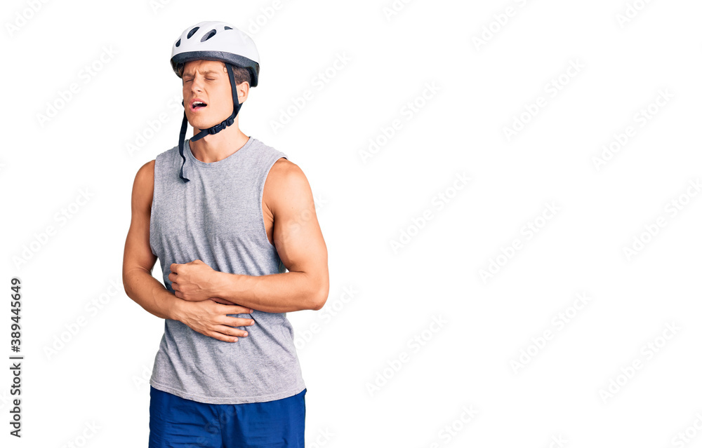 Young handsome man wearing bike helmet with hand on stomach because nausea, painful disease feeling unwell. ache concept. Young handsome man wearing bike helmet with hand on stomach because nausea, painful disease feeling unwell. ache concept.