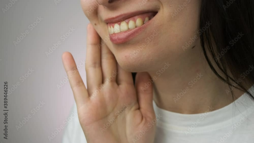 Front view of woman removing invisible transparent aligner from the upper jaw and demonstrate smile. Front view of woman removing invisible transparent aligner from the upper jaw and demonstrate smile.