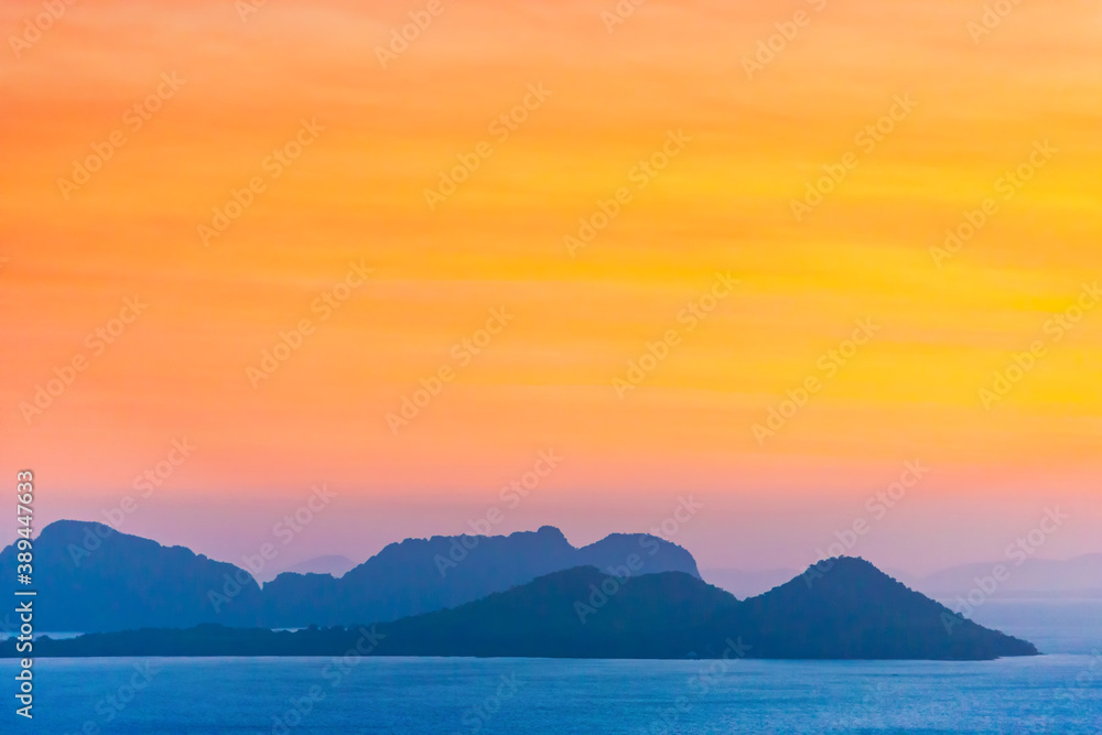 Mountain landscape on sunset sea with colorful sunset sky