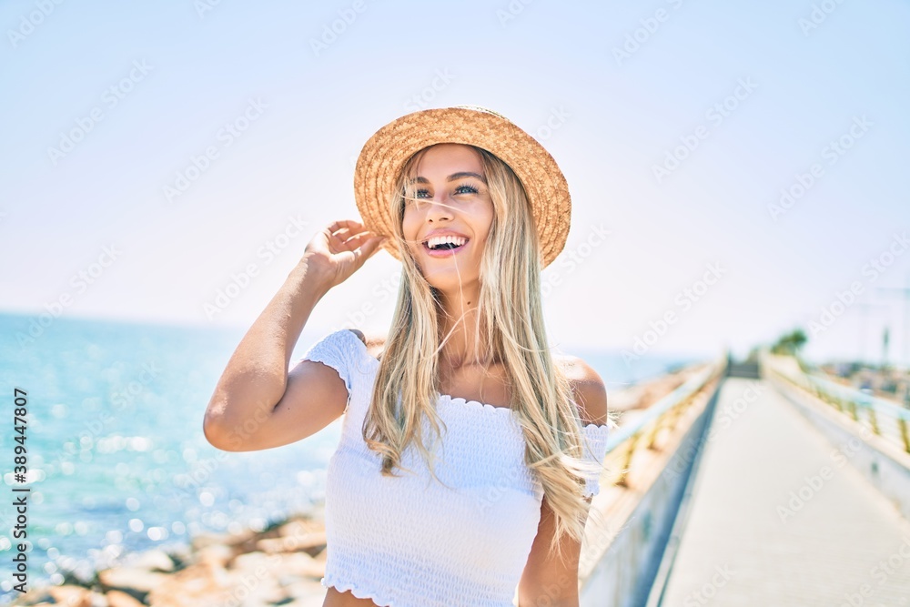 Young blonde tourist girl smiling happy looking to the side walking at the promenade.