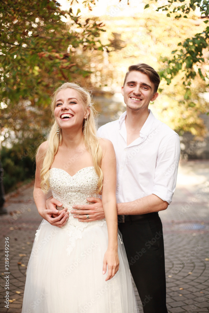 Fototapeta premium Joyful young couple of lovers dancing together on a wedding day in autumn courtyard