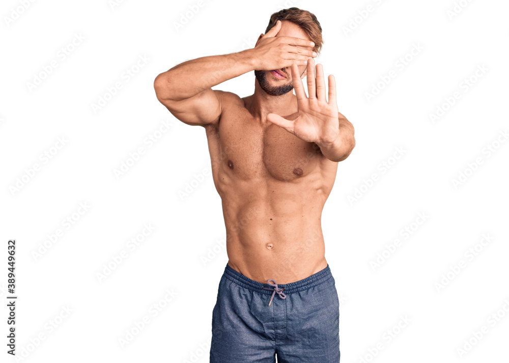 Fototapeta premium Young caucasian man standing shirtless covering eyes with hands and doing stop gesture with sad and fear expression. embarrassed and negative concept.