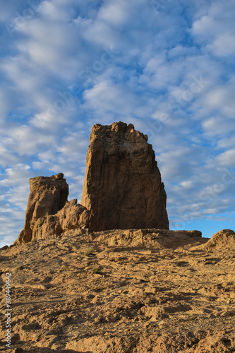 Roque nublo photographed at sunset with a slightly cloudy blue sky.