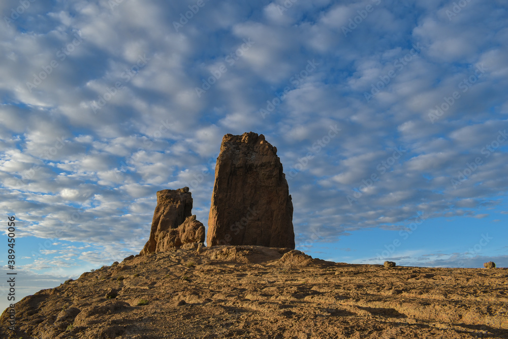 Roque nublo photographed at sunset with a slightly cloudy blue sky.