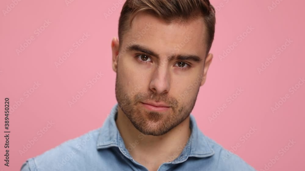 sensual young guy in denim shirt holding hand behind neck and posing in a seductive manner, standing on pink background in studio sensual young guy in denim shirt holding hand behind neck and posing in a seductive manner, standing on pink background in studio