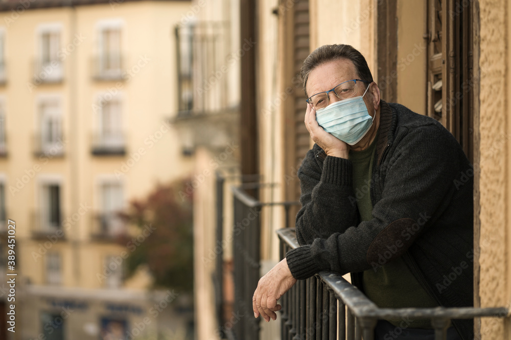 mature man in balcony home lockdown during covid19 outbreak - senior male on his 70s in face mask worried and tired looking to the street thoughtful and depressed in quarantine mature man in balcony home lockdown during covid19 outbreak - senior male on his 70s in face mask worried and tired looking to the street thoughtful and depressed in quarantine