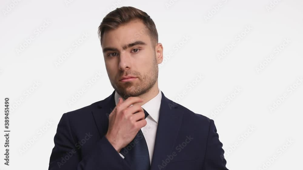 pensive businessman holding hand to chin and thinking, buttoning navy blue suit and fixing tie, crossing arms, looking down side and posing on white background in studio pensive businessman holding hand to chin and thinking, buttoning navy blue suit and fixing tie, crossing arms, looking down side and posing on white background in studio