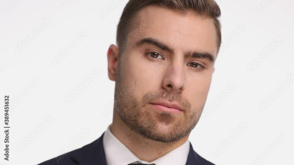 attractive young guy in navy blue suit looking down, moving head and posing, holding hand to chin and thinking, smiling isolated on white background attractive young guy in navy blue suit looking down, moving head and posing, holding hand to chin and thinking, smiling isolated on white background