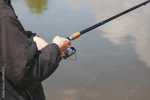 Fisherman hands holding fishing rod close-up