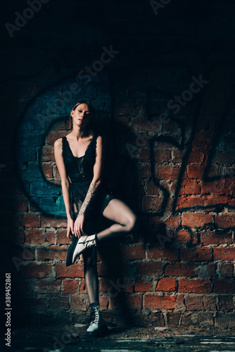 Beautiful young slim woman in elegant underwear posing against the backdrop of a brick walls. Concept of female beauty and grace
