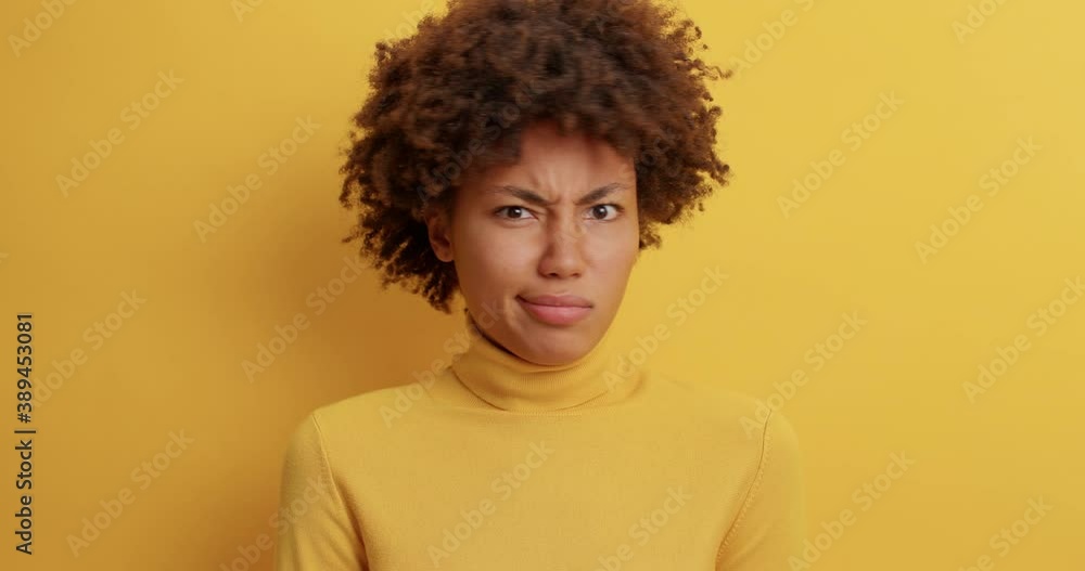 Skeptical displeased Afro American woman says no and nods head refuses awful offer dislikes your idea shrugs shoulders says its not very good rejects proposal dressed in casual clothing poses indoor Skeptical displeased Afro American woman says no and nods head refuses awful offer dislikes your idea shrugs shoulders says its not very good rejects proposal dressed in casual clothing poses indoor