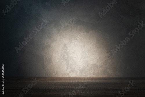 Table top on background of concrete wall with ray of light