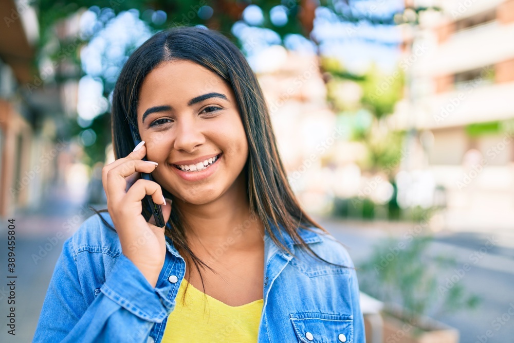 Young latin woman smiling happy talking on the smartphone at city Young latin woman smiling happy talking on the smartphone at city