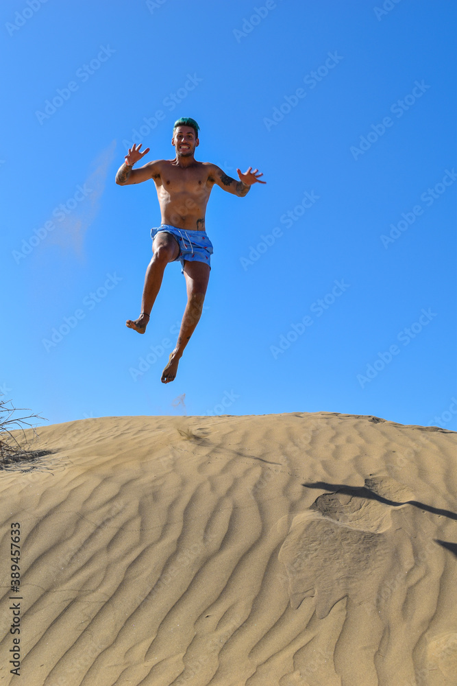 Man on vacation, running and jumping in the desert sand dunes. Man on vacation, running and jumping in the desert sand dunes.