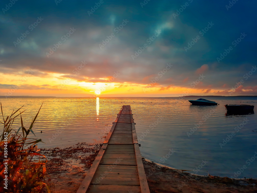 Fototapeta premium Magic sunrise on the lake. Late fall. Pier going into the horizon