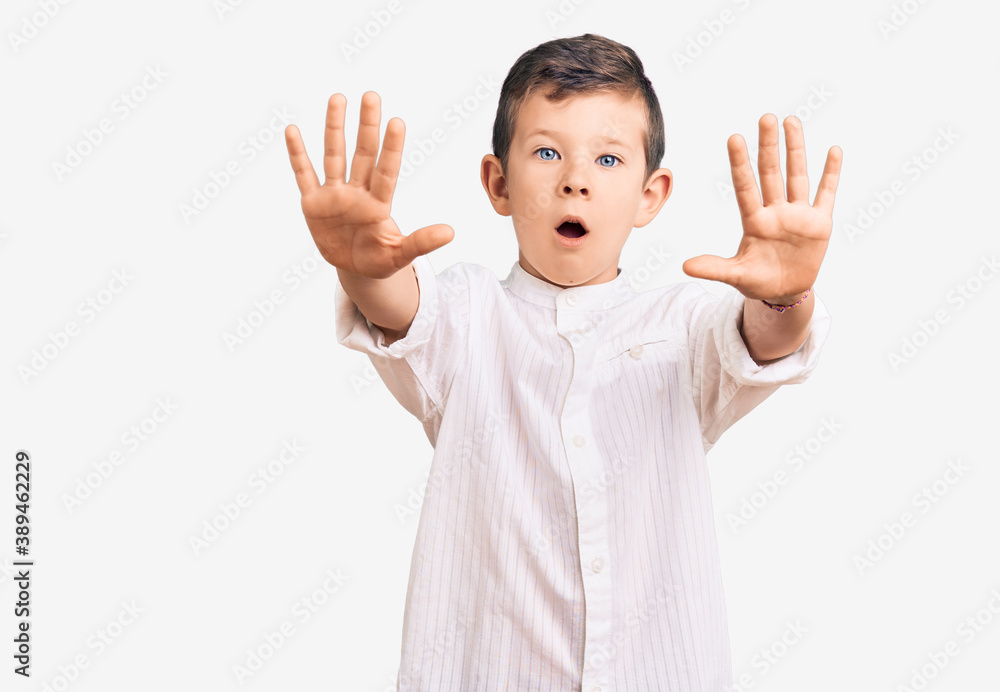 Cute blond kid wearing elegant shirt doing stop gesture with hands palms, angry and frustration expression Cute blond kid wearing elegant shirt doing stop gesture with hands palms, angry and frustration expression