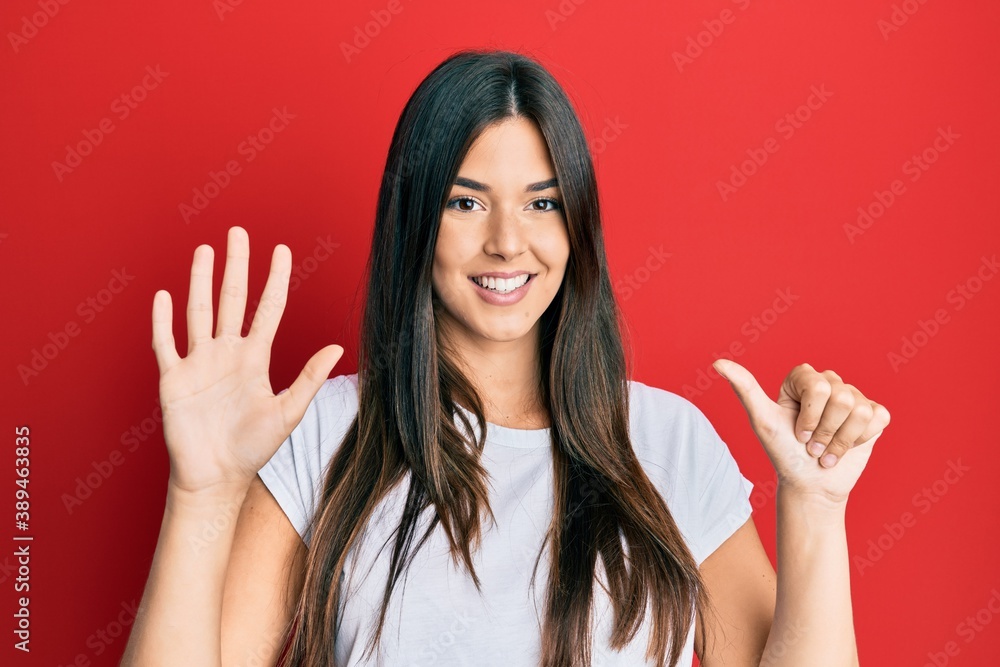 Young brunette woman wearing casual white tshirt over red background showing and pointing up with fingers number six while smiling confident and happy. Young brunette woman wearing casual white tshirt over red background showing and pointing up with fingers number six while smiling confident and happy.