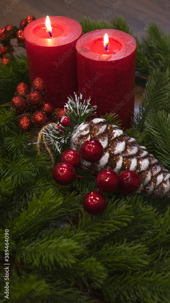 Red candles with fir branches and a toy pine cone. Dark Christmas and New Year background. Red candles, green spruce branches, red berries. Red candles with fir branches and a toy pine cone. Dark Christmas and New Year background. Red candles, green spruce branches, red berries.