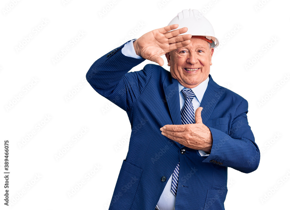 Senior handsome grey-haired man wearing suit and architect hardhat smiling making frame with hands and fingers with happy face. creativity and photography concept. Senior handsome grey-haired man wearing suit and architect hardhat smiling making frame with hands and fingers with happy face. creativity and photography concept.