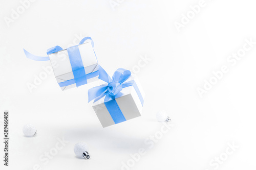 Christmas decoration blue background. White gifts with blue ribbon and New Year balls in xmas decoration on white background for greeting card. Decoration and copy space for your text.