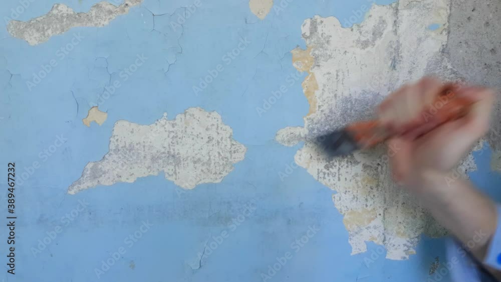 Apartment renovation. Process of peeling walls from old paint. Peeling