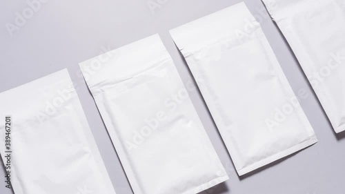 Lot of white paper bubble envelopes on grey background, textured background