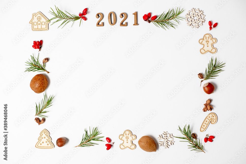 Christmas frame, decorative border. Winter composition of numbers 2021, fir branches, red berries, New Year's toys on a white background. Flat lay and copy space.