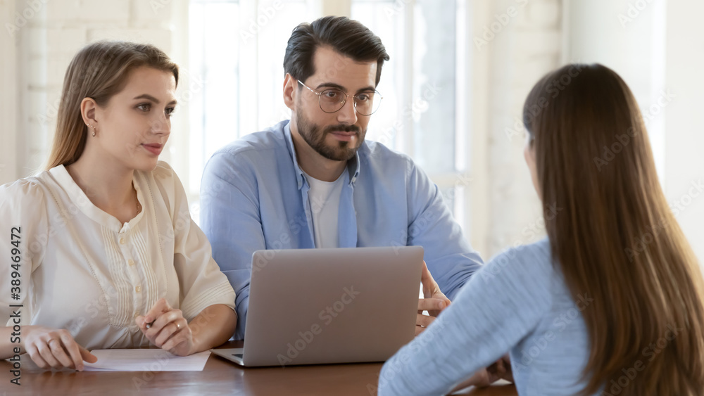 Job interview. Two diverse recruiters hr managers of business company having conversation with young woman applicant, attentive male and female employers asking questions to candidate on vacant place Job interview. Two diverse recruiters hr managers of business company having conversation with young woman applicant, attentive male and female employers asking questions to candidate on vacant place
