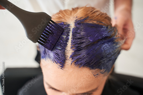 Man holding the brush and brightens the roots of the hair photo