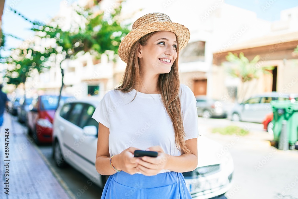 Young blonde woman on vacation smiling happy using smartphone at street of city