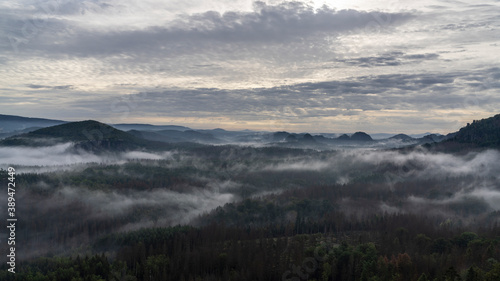 Panoramablick in den Morgenstunden von den Affensteinen über den Neuen Wildenstein mit dem legendären Kuhstall bis zum Kleinen Winterberg. Die Sonne schickt ihre wärmenden Strahlen durch den Nebel. © zimuwe