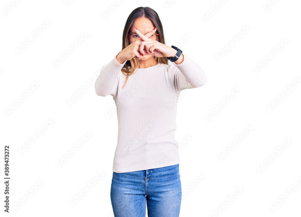 Beautiful brunette young woman wearing casual white sweater and glasses rejection expression crossing fingers doing negative sign Beautiful brunette young woman wearing casual white sweater and glasses rejection expression crossing fingers doing negative sign