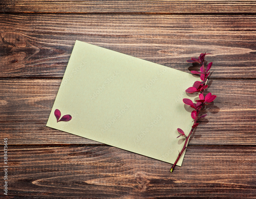 Autumn branch of barberry with envelope on brown wooden background. Autumn branch of barberry with envelope on brown wooden background.