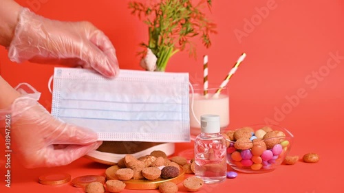 Dutch holiday Sinterklaas. hildrens shoe with carrots for Santa's horse, pepernoten and sweets . Gloved hands are rubbed with antiseptic, sanitizer and a protective mask. photo