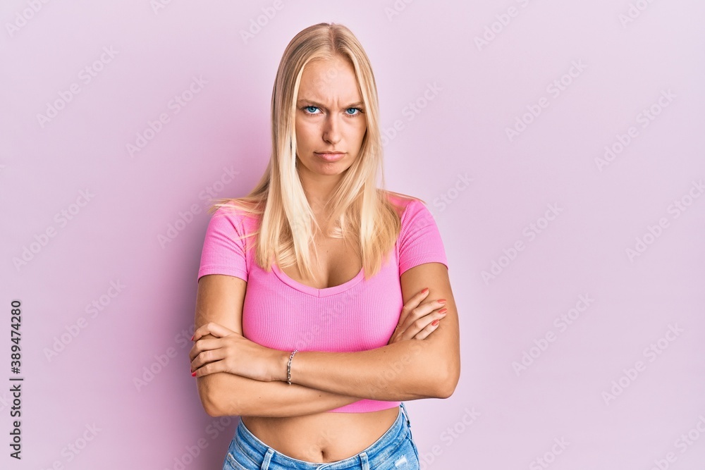 Young blonde girl wearing casual clothes skeptic and nervous, disapproving expression on face with crossed arms. negative person. Young blonde girl wearing casual clothes skeptic and nervous, disapproving expression on face with crossed arms. negative person.