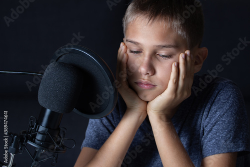 Young teenage boy sitting in front of microphone. Close up portrait