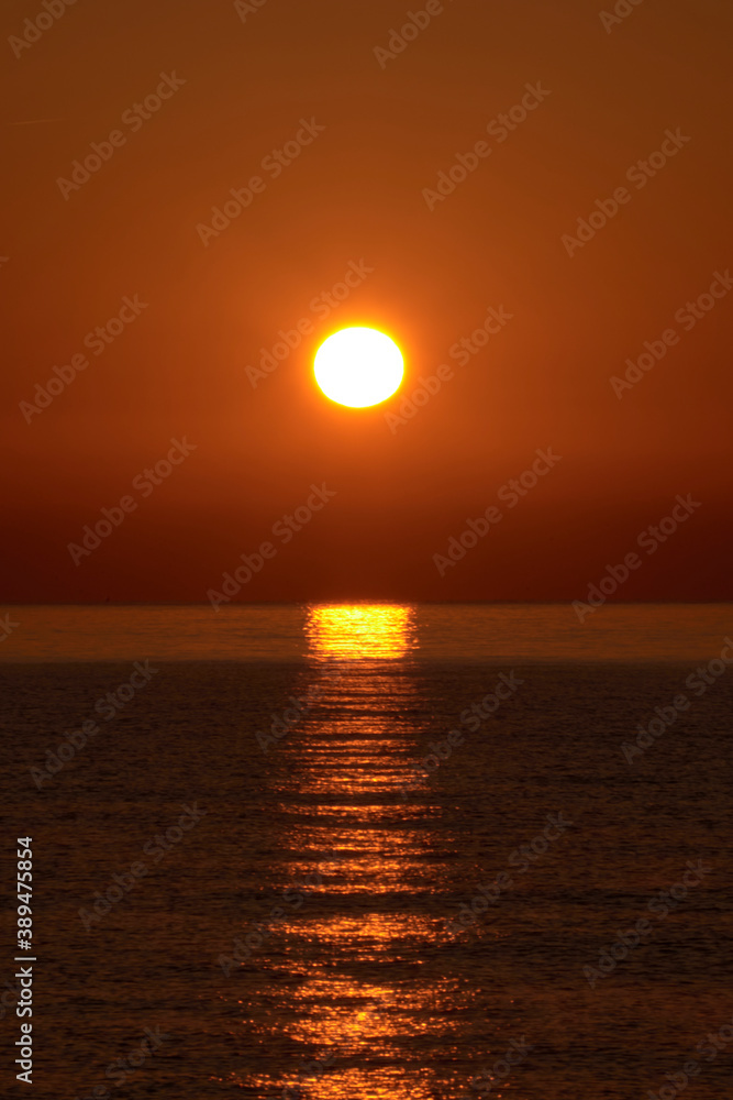 Sunrise on the beach, sun on the water