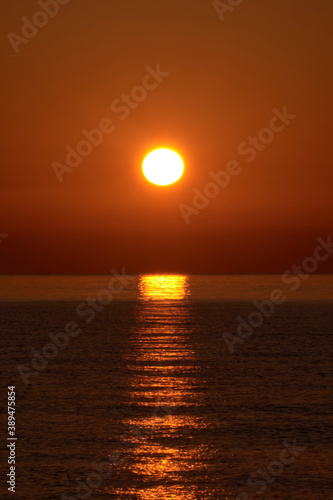 Sunrise on the beach, sun on the water © Raul