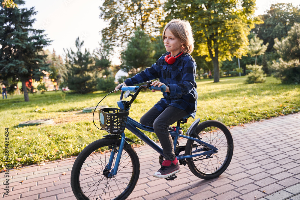 Fototapeta premium Child riding bicycle on a street