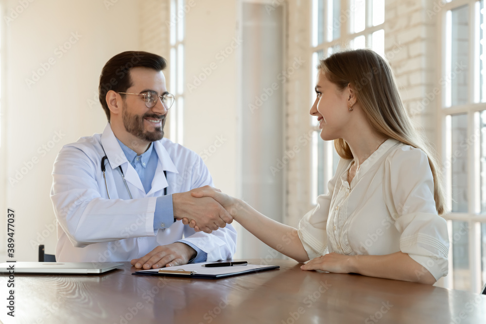 Thank you for help, doctor. Happy grateful young woman patient handshaking with male physician appreciating for good effect of treatment, satisfied with better health state, signing insurance policy Thank you for help, doctor. Happy grateful young woman patient handshaking with male physician appreciating for good effect of treatment, satisfied with better health state, signing insurance policy