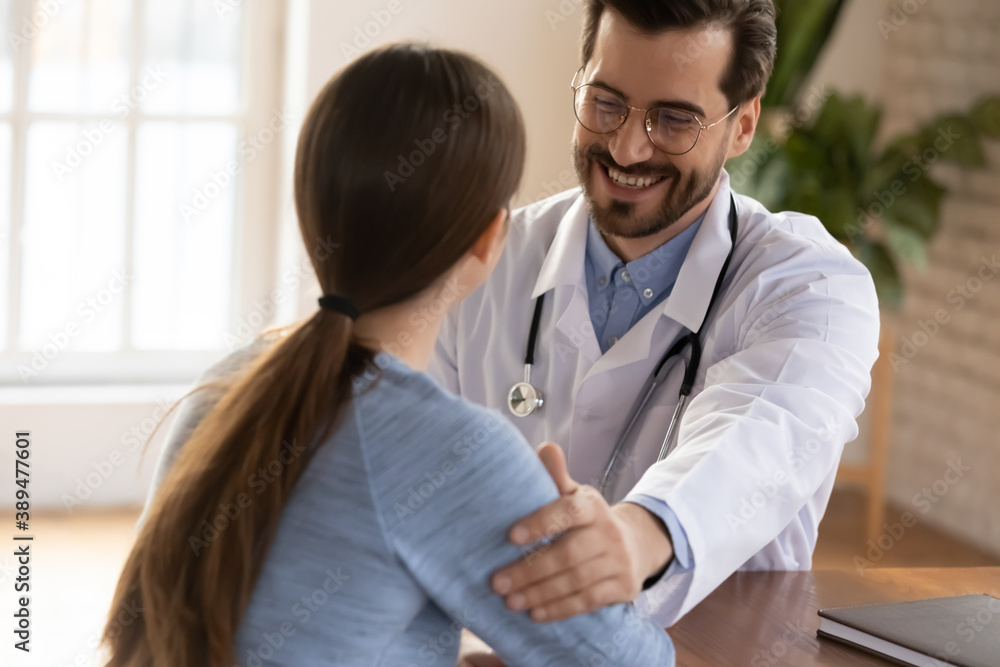 Happy practitioner greeting teen girl patient with good results of medical examination, glad attending physician telling young woman patient about recovery of health or remission of chronic disease Happy practitioner greeting teen girl patient with good results of medical examination, glad attending physician telling young woman patient about recovery of health or remission of chronic disease