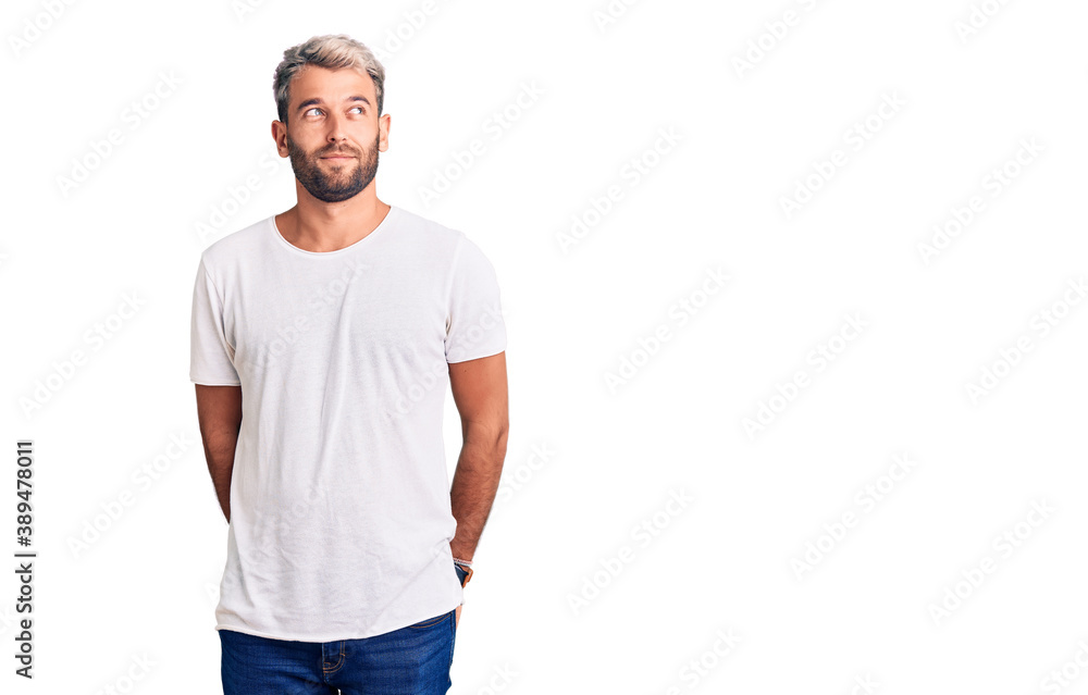 Young handsome blond man wearing casual t-shirt smiling looking to the side and staring away thinking. Young handsome blond man wearing casual t-shirt smiling looking to the side and staring away thinking.