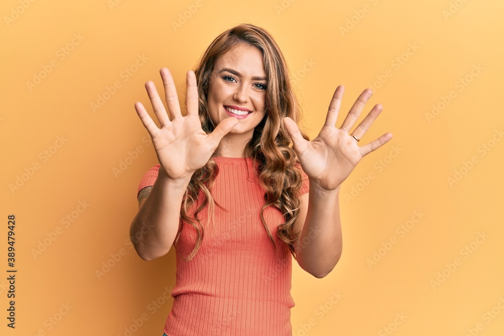 Young blonde girl wearing casual clothes showing and pointing up with fingers number ten while smiling confident and happy. Young blonde girl wearing casual clothes showing and pointing up with fingers number ten while smiling confident and happy.
