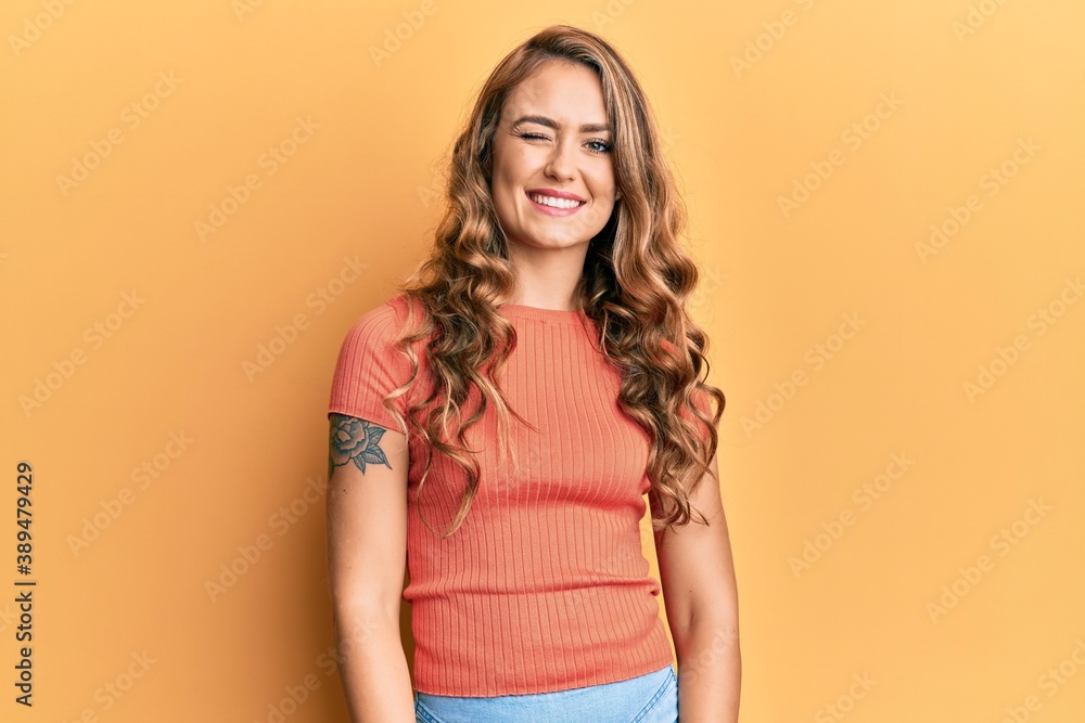 Obraz premium Young blonde girl wearing casual clothes winking looking at the camera with sexy expression, cheerful and happy face.