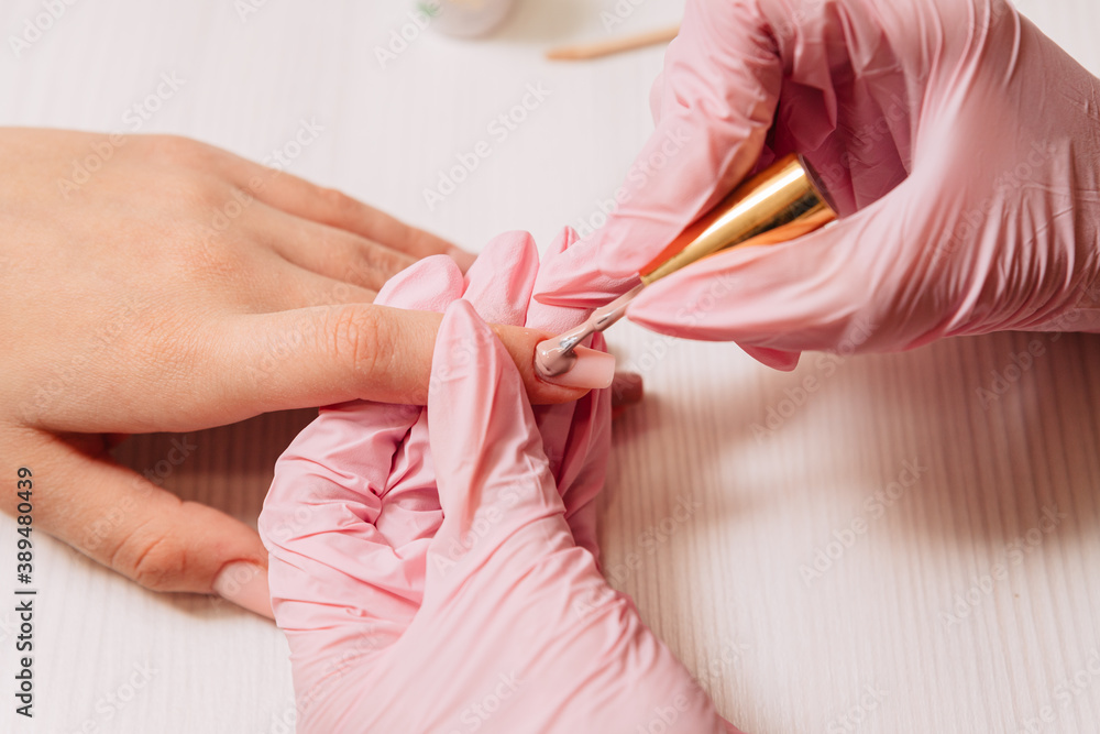Naklejka premium Manicure process. Manicurist paints fingernails. Nail polish.