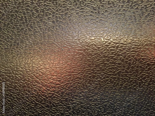 Metal corrugated sheet. heterogeneous metal texture. Glare of different colors on metal.